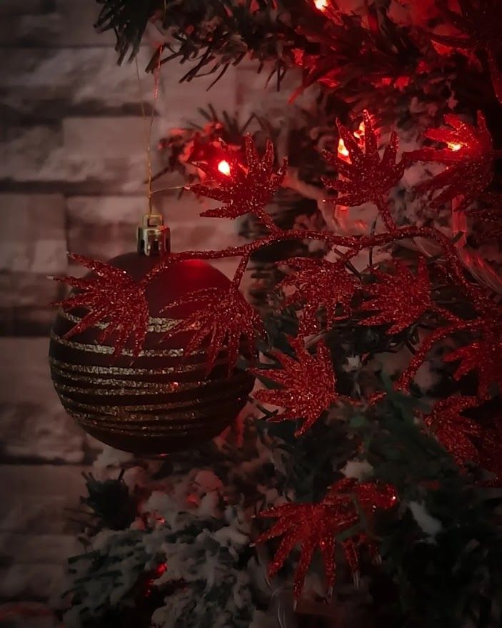 A beautifully decorated Christmas tree with all the handmade ornaments lights and festive touches