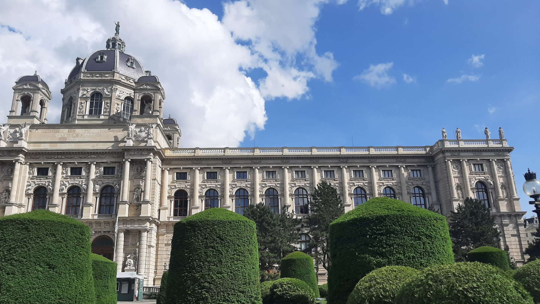 The yellow Baroque facade of Schönbrunn Palace under a bright blue sky in Vienna