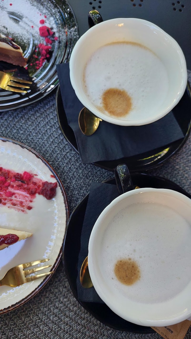 two cups of coffee and two plates with cheesecakes