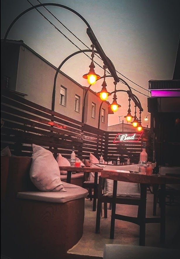 Atmospheric bar with decorative light bulbs creating a magical summer evening vibe in Greece