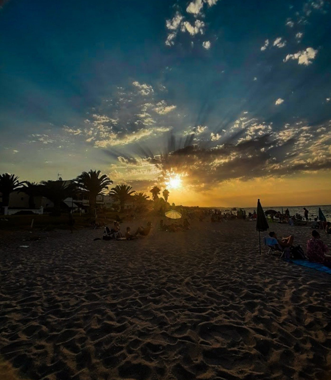 A breathtaking sunset over the sandy beach in Pefkochori Greece with warm golden light on the water