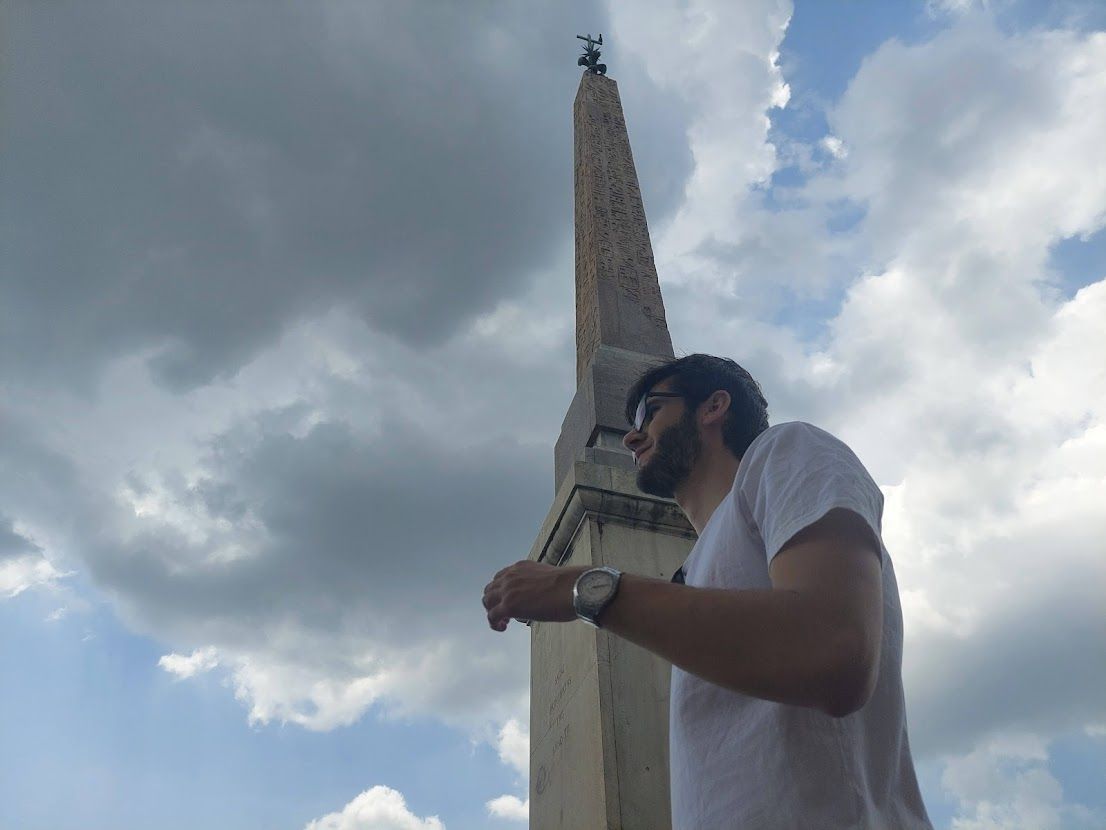 One of Romes many Egyptian obelisks with a pyramid-like top standing tall against the Italian sky