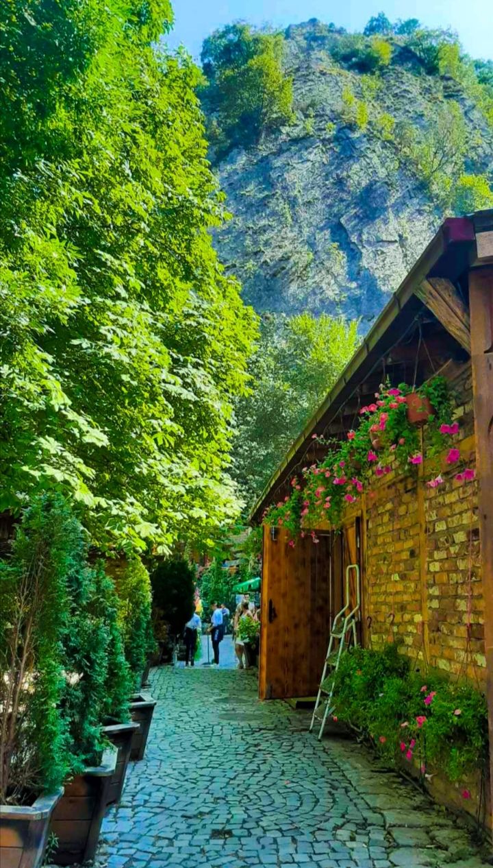 A cozy lakeside restaurant at Canyon Matka with tables overlooking the turquoise water and canyon walls