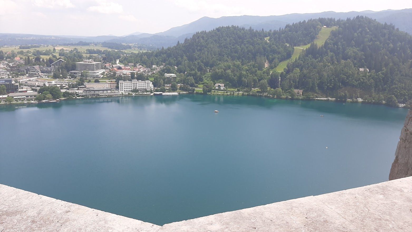 A wide panoramic view of Bled Lake with its emerald water island and surrounding Alpine peaks