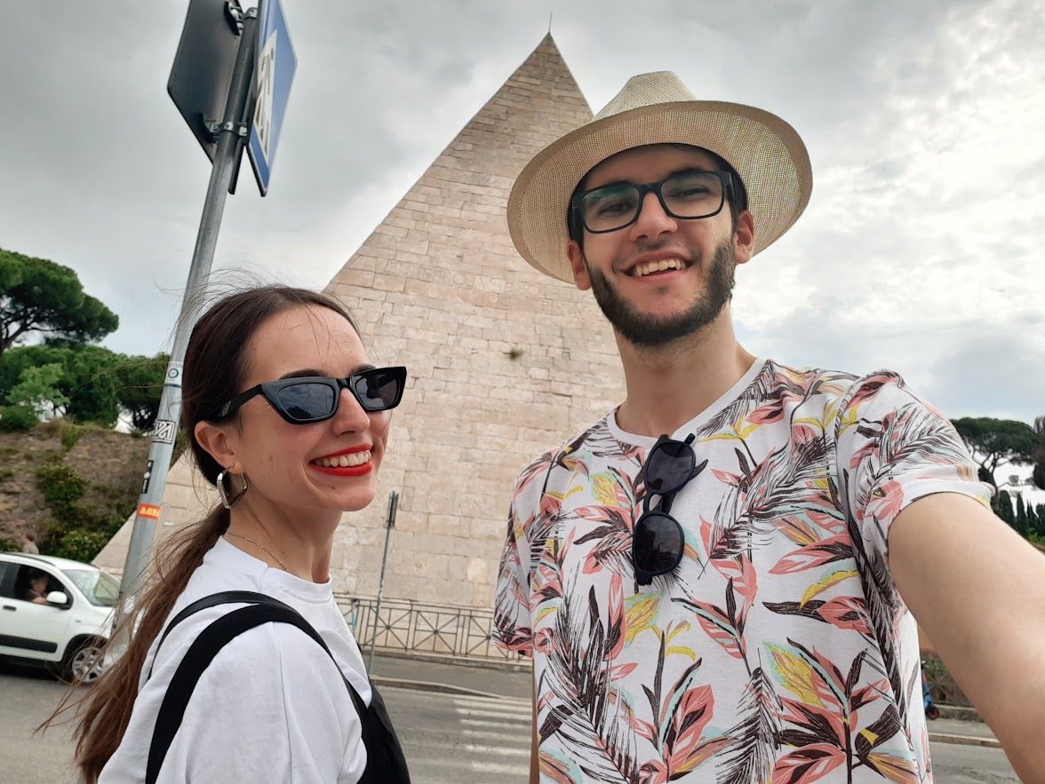 A couple photo in front of the Pyramid of Cestius an unexpected Egyptian monument in the heart of Rome