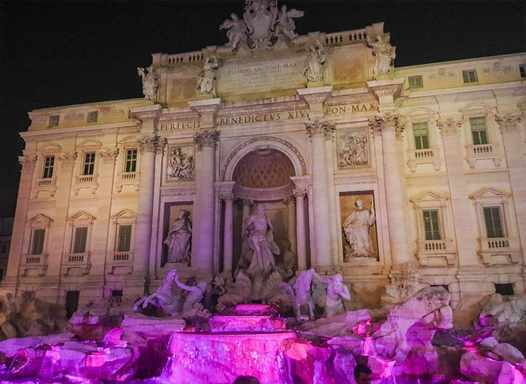 The staggeringly marvellous Fontana Di Trevi in baroque style with tourists tossing coins for good luck