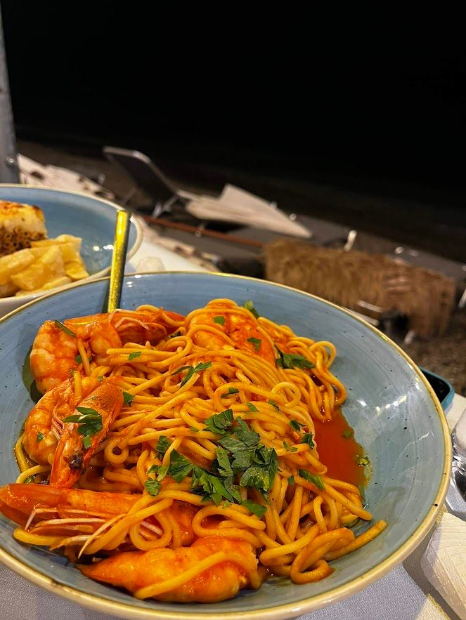 Delicious Greek spaghetti with prawns served at a seaside restaurant with fresh sea air