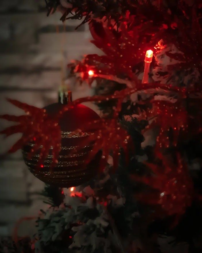 Warm Christmas decorations with a glowing candle surrounded by handmade ornaments and festive lights