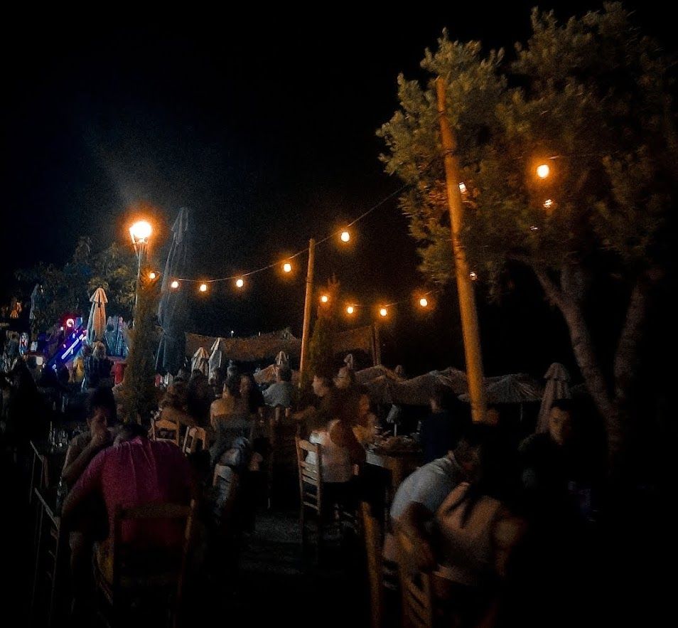 A cozy seaside restaurant in Greece with a beautiful sea view perfect for an evening dinner