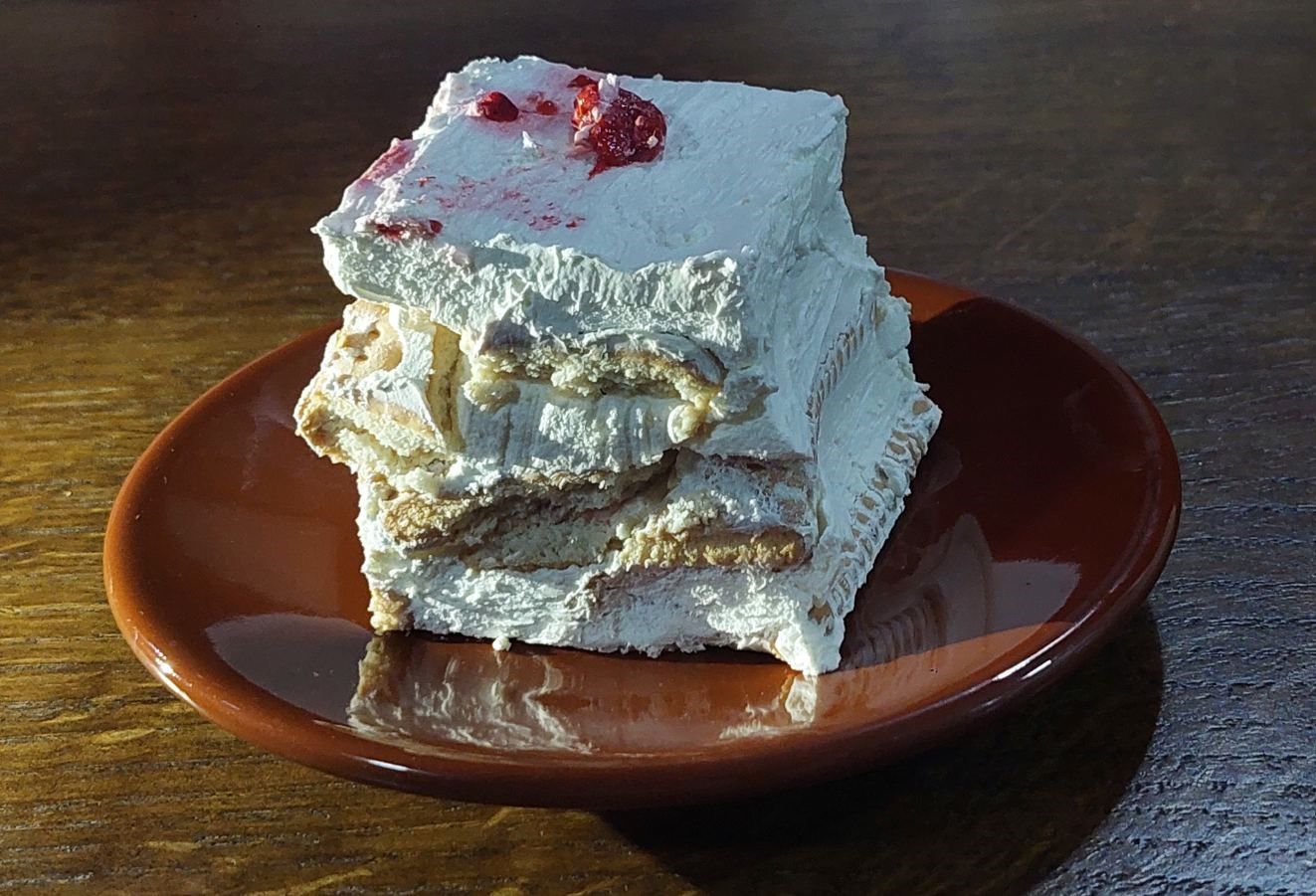 A beautiful slice of the layered biscuit cake showing the creamy sweet cream and soft biscuit layers