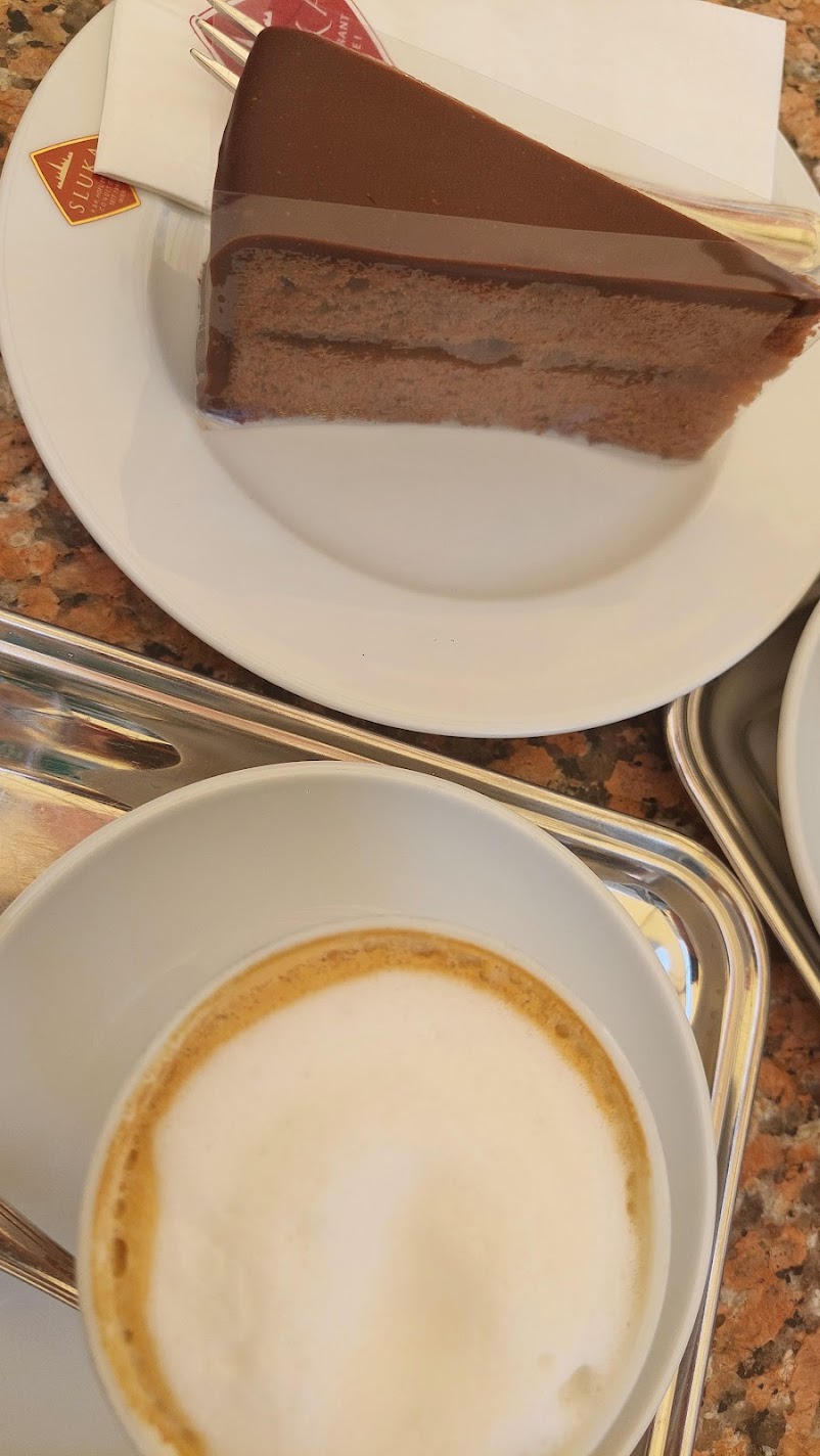 A slice of Sachertorte chocolate cake served with a Viennese melange coffee