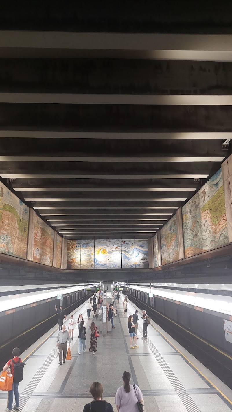 A Vienna U-Bahn underground station with a mural above the platforms