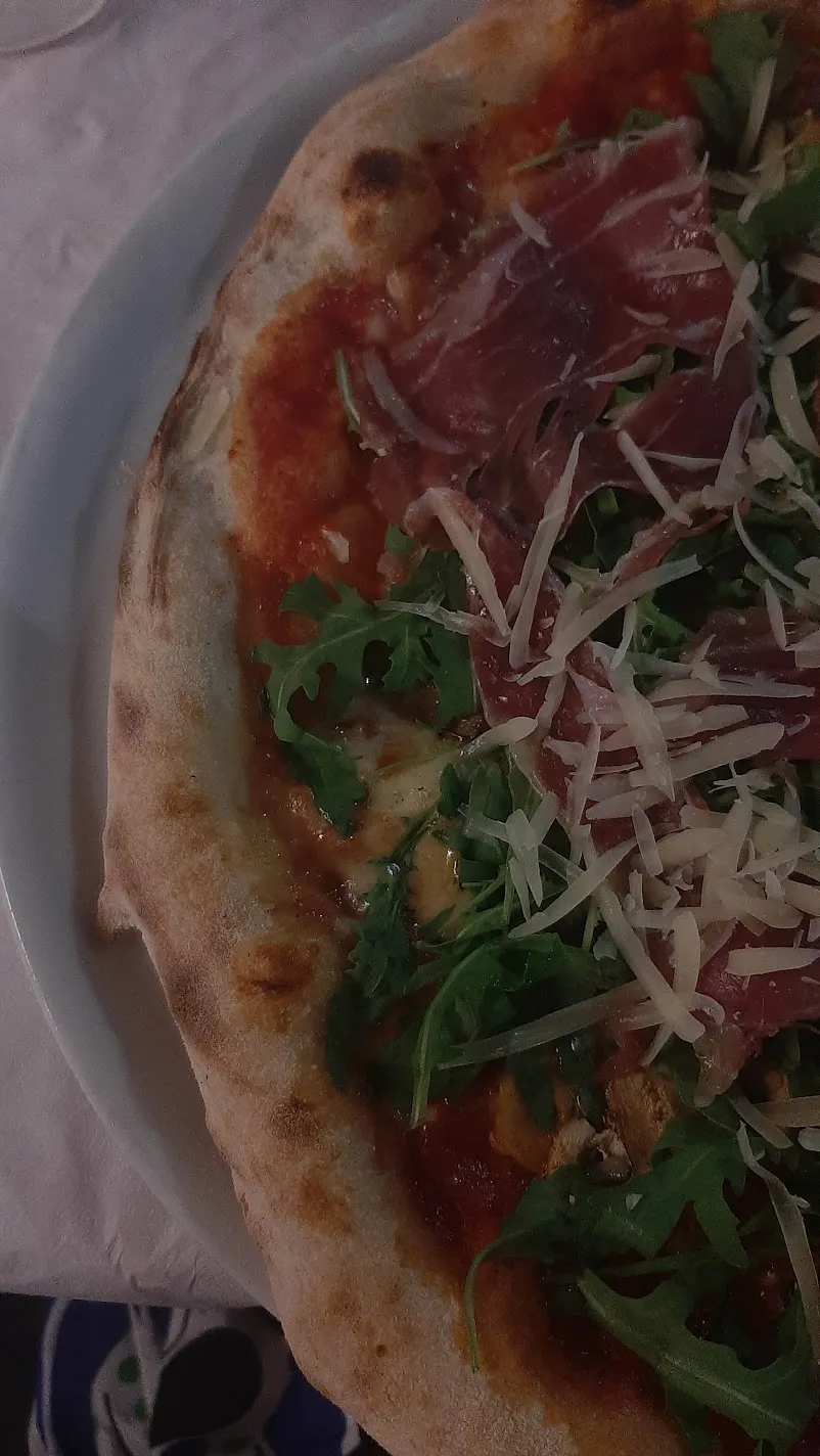 A Sicilian pizza topped with prosciutto, rocket and shaved cheese