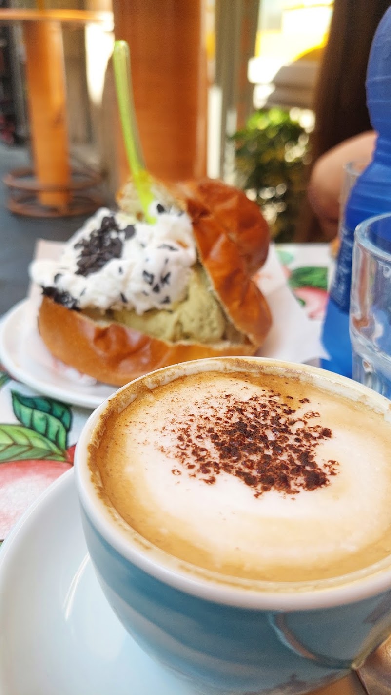 A brioche filled with pistachio gelato and cream, served with a cappuccino in Sicily